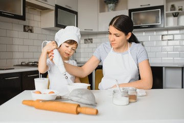 Son and mother preparing dough together