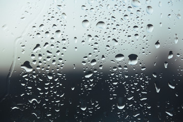Macro pure rain drops on the glass against a cloud gray background