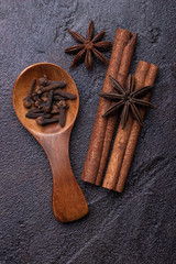Fototapeta na wymiar Anise, cinnamon sticks and cloves in a wooden spoon