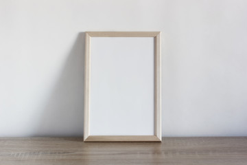 empty white frame on a wooden table.