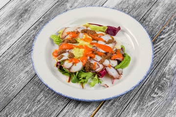With seafood salad in plate on wooden background