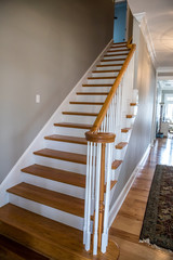light-colored and white painted hardwood stairs stairway in a modern updated new construction home with a white banister