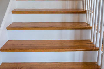 light-colored and white painted hardwood stairs stairway in a modern updated new construction home with a white banister