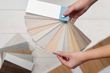 Designer architect holds a palette of textures and decor for a wooden floor made of laminate and...