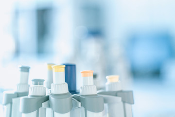 Laboratory pipettes on blurred laboratory background. Research and development concept with free space for text.