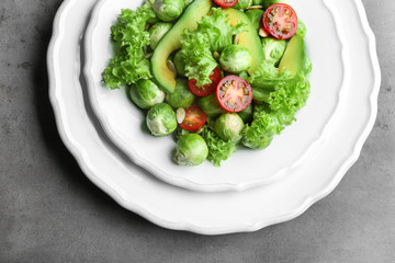 Tasty salad with Brussels sprouts on grey table, top view