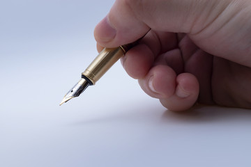 Fountain pen hold in hand and waiting for signing document with narrow focus as business concept