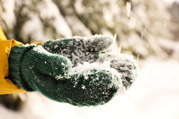 Woman playing with snow outdoors, closeup. Winter vacation