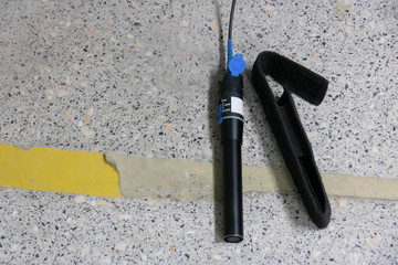 Closeup hand holding fiber optic cables with visual fault locator laser in the networking...