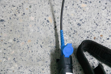 Closeup hand holding fiber optic cables with visual fault locator laser in the networking...