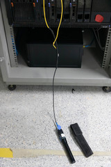 Closeup hand holding fiber optic cables with visual fault locator laser in the networking...