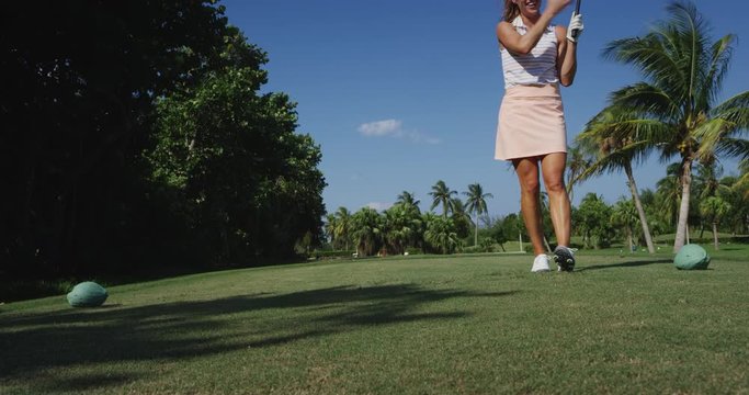 Athletic Woman driving golf ball