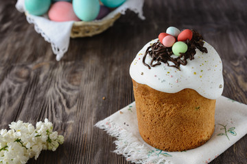 Easter cake decorated on top with chocolate and colored sweet balls in the shape of a nest and eggs