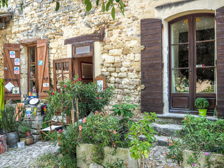 Fototapeta na wymiar Doorways and windows of quaint buildings in Provence surrounded by greenery.