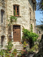 Fototapeta na wymiar Medieval windows arches and doors in Provence, surrounded by greenery.