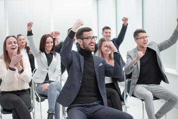 jubilant group of young people applauds in the conference room
