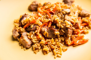 Traditional Uzbekistan pilaf on the rustic background. Selective focus. Shallow depth of field.