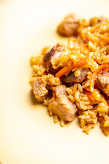 Traditional Uzbekistan pilaf on the rustic background. Selective focus. Shallow depth of field.