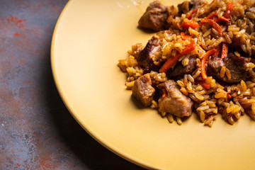 Traditional Uzbekistan pilaf on the rustic background. Selective focus. Shallow depth of field.