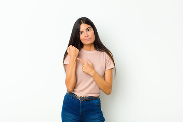 young pretty latin woman looking impatient and angry, pointing at watch, asking for punctuality,...