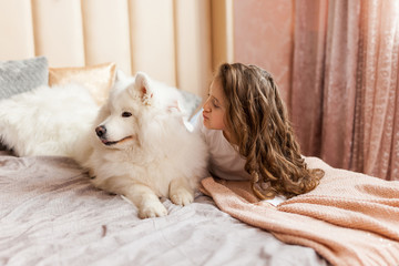 Home portrait of cute child hugging with dog on the sofa