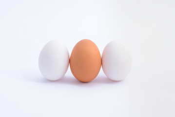 three upright  eggs(white and brown) on white background