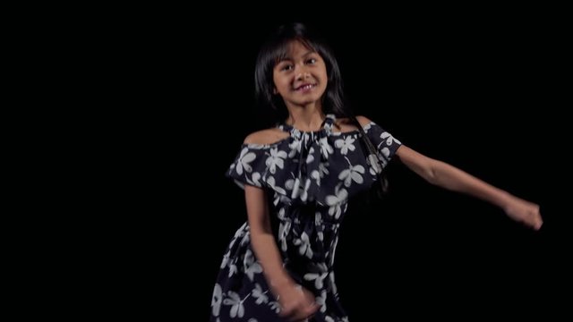 A little asian girl dances the floss dance
