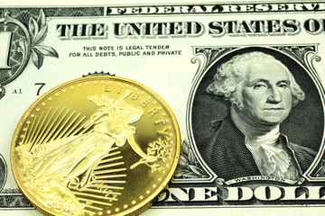 A macro image of a green American one dollar bill with a gold coin.  Shot close up.