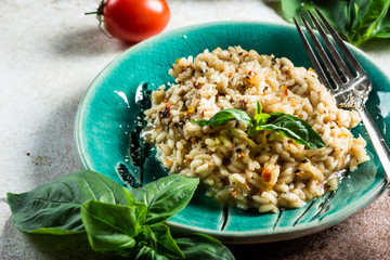 Risotto with tomatoes on a green plate with basil. Italian food. Vegan food concept. Italian cuisine. Tomato dish. Healthy food. Summer dish. Homefood.