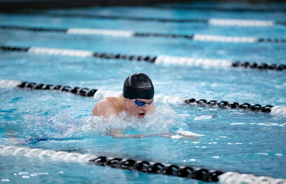 Young male swimmer swims the breaststroke in a competition