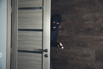 burglar sneaking into the house with flashlight