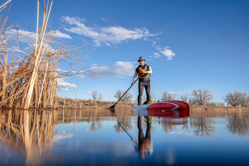 senior male paddling stand up paddleboard