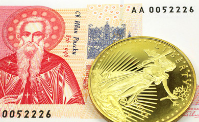 A macro image of a red and white Bugarian one lev note with a gold coin.  Shot close up.
