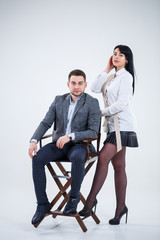Obraz premium Successful man in a suit and a woman future businessmen are smiling and talking about a new project. Business partners stand on a white background.