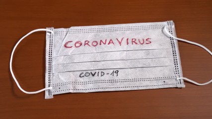 Hand with dollar bills uncovering a face mask with the word coronavirus . USA stock markets, financial crisis and Stimulus bill caused by the coronavirus outbreak - Powered by Adobe