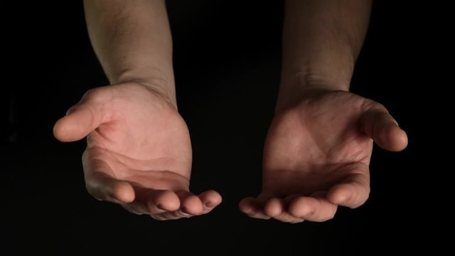 Human male palms isolated on black background. Close up.