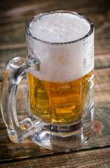 Light beer in a glass, on an old background.