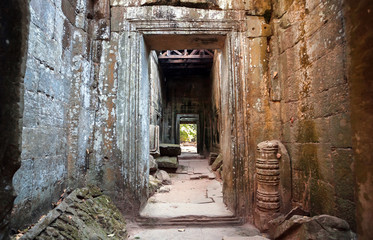Fototapeta na wymiar Narrow corridor in maze of the 12th century temple in Angkor, Cambodia. Historical structure