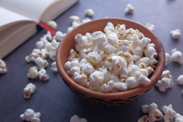 close up of popcorn in bowl and book on table 