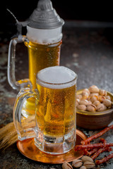 Light frothing beer in a glass, on an old background.