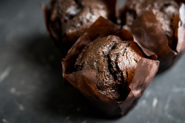 Homemade chocolate muffin on the rustic background. Selective focus.