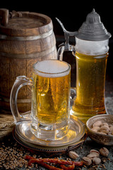 Light frothing beer in a glass, on an old background.