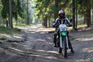 off-road motorcycle trip in the forest, beautiful girl, feminism, sport, brutality, motorcyclist equipment, motorcycle driver, concept, active lifestyle, enduro