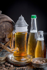 Light frothing beer in a glass, on an old background.