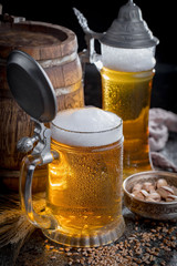 Light frothing beer in a glass, on an old background.