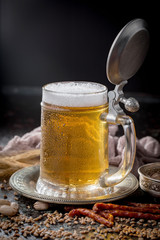 Light frothing beer in a glass, on an old background.