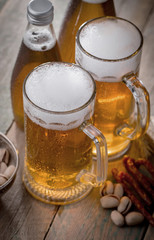 Light frothing beer in a glass, on an old background.