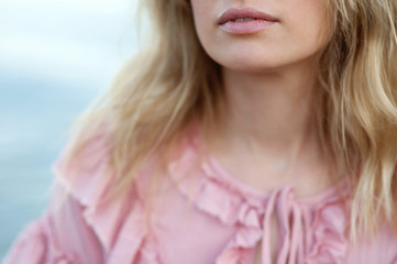Close-up fragmentary  portrait of a beautiful  European girl in a pink dress