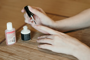 home manicure on the kitchen table on a wooden mat