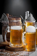 Light frothing beer in a glass, on an old background.